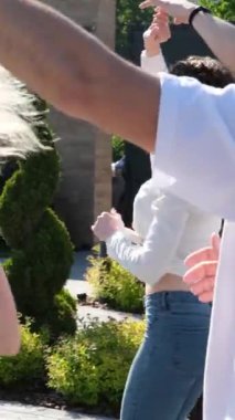 Sanatçı dansçıları, sokaktaki bir gösteriden önce dört çift aynı koreografili bachata hareketlerini yaparlar. Beyaz tişört ve kot pantolon