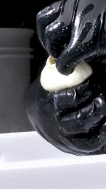 Mutfakta, koruyucu saç şapkasının önünde peynir hazırlayan bir kadın. Peyniri saf ineklerin sevgisiyle hazırla süt ve keçilerin sütüyle.