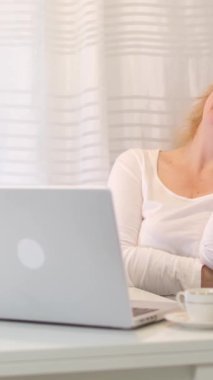 Kadın telefonda gülerek konuşuyor. Telefon konuşmasını bitirdi. Evdeki bilgisayarın bilgisayarına baktı. 