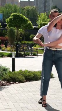 Çeşitli çiftler dans ediyor. Yaşam tarzı, rahatlık ve birlikte zaman geçirmek. Sokak dansı, parkta dans gösterisi.