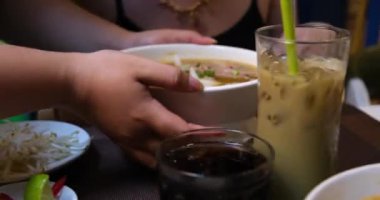 Pirinç vermicelli pirinç şehriye çorbası restoranda çorba pilav erişteli erişte, vermicelli kız Vietnam yemeklerini kokluyor iştah açıcı seyahat yemekleri yiyor. Sokak yemeği. Pirinç vermicelli çorbası Vietnam