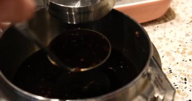 Bu yavaş çekim videosu anonim hibachi şefinin elleri masada sos kaplarına kepçeyle lezzetli soslar servis ederken görülüyor..