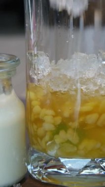 Tatlı olarak hindistan cevizi bazlı şurupta küçük siyah ve yeşil jöle kalıpları karıştırmak. Bireysel fincanlara servis hazırlığı. Ev yapımı tarif. Asya 'da reçel