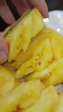 Soyulmuş tropikal ananas meyvelerini beyaz kesim tahtasında şef bıçağıyla dilimlemek. Soyulmuş ananas