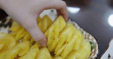 Soyulmuş tropikal ananas meyvelerini beyaz kesim tahtasında şef bıçağıyla dilimlemek. Soyulmuş ananas