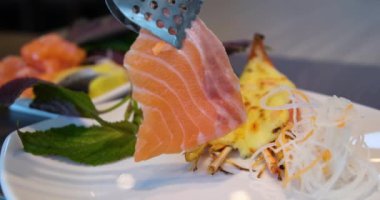 Suşi şefi suşi barında taze somon dilimler. Suşi adam Japon bıçağıyla somon bifteğini dilimliyor. Suşi nigiri balığı hazırlıyorum. Japon mutfak tarifleri..