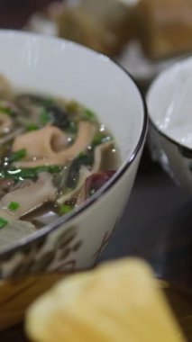 Tom Yum geleneksel Tayland yemeği yapıyor. Birisi kaynar su dolu bir tencerede mantar karıştırıyor. Kral istiridye mantarı, Anka mantarı, akciğer istiridyesi. Çekim.