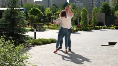 Genç bir çift doğada bachata dansı yapıyor, uzun boylu, güçlü bir adam, kıvırcık saçlı bir kız, yakışıklı Avrupalılar. Bachata dışarıda.