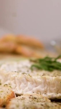 Pişirmeden önce, peynirin üzerine kızarmış ekmek ve vişneli domates serpin. Provenkal bitkiler