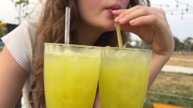 Avrupalı bir kız sokak yemeklerinde otururken kamış şekeri içer. Vietnam 'da tatil