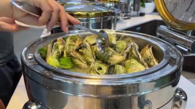 Farklı balık türlerinden aperatiflerle süslenmiş güzel bir ziyafet masası, soslar ve istiridye kabuklu havyar. Restoran büfesi haşlanmış istiridye.
