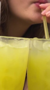 Avrupalı bir kız sokak yemeklerinde otururken kamış şekeri içer. Vietnam 'da tatil