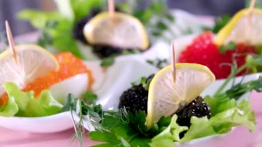 Tabaktaki kırmızı ve siyah havyar, limonlu bir tekne şeklinde bir büfe tepsisinde döner. Zengin, baharatlı yumurta lüks otel.