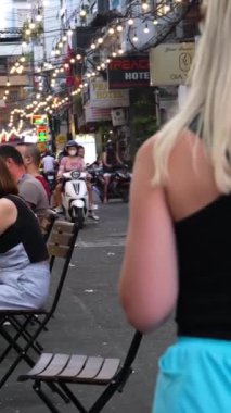 Saigon 'da akşam vakti gerçektir. İnsanlar şehirde dolaşıyor, kafelerde oturuyor, motosiklet ve araba sürüyor, turistler ve Asyalılar ve Avrupalılar birlikte zaman geçiriyorlar. Vietnam Ho Chi Minh Şehri 06.03.2024