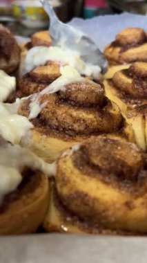 Ev yapımı tarçınlı rulolara krem peynir serpiştirmek. Cinnabon 'u Aç
