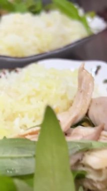 Tavuklu pirinç Asya 'yı yeşillendirir. Haşlanmış tavuk, haşlanmış pirinç, pembe tabak..