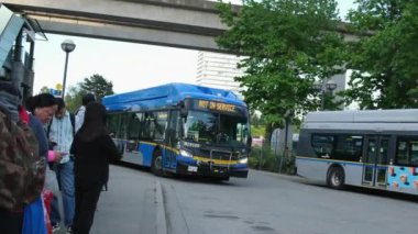 Vancouver 'da insanlar otobüsün gelmesini bekliyor. Hava eğitmeni Kanada yakınlarındaki otobüs durağı Surrey 06.07.2024