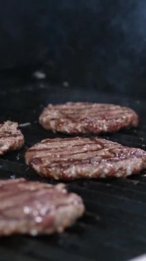 Hamburger yemeği, kızarmış profesyonel şef, elleri aşağıda, siyah eldivenlerle hazırlanıyor. Ağır çekimde kapat 