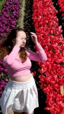 Gökkuşağıyla çiçek bahçesinde oynayan bir kız