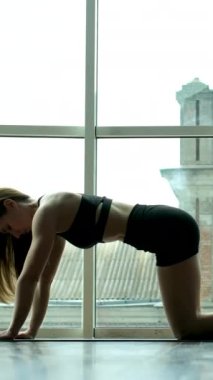 Genç kadın blogcu telefonla yoga yaparken video çekiyor. Spor ve spor. Eğitim, egzersiz ve sağlık konsepti. Karantina sırasında.