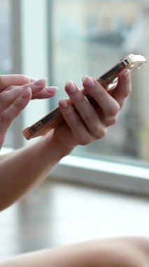 Yoga minderinde uzanan ve cep telefonunda sosyal medyada gezinen Latin genç bir kız. Bayan dans öğretmeni kadın koreografi çalışıyor.