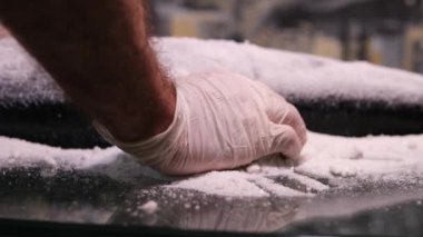 Lastik eldivenli kişi taze somon filetosunu tuzlu füme somon hazırlamaya nazikçe bırakıyor. Tuzlu somon