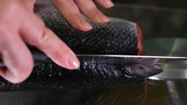 Erkek eller balık kafası keser. Balıkçı taze balıkları inceliyor. Balık endüstrisi. Balığı kesmek