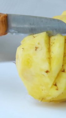 Ananası ustalıkla küçük dilimler halinde kesen birinin yakın çekim görüntüleri..
