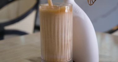 Sütlü krema buzlu kahveye dökülür. Buzlu ve sütlü soğuk kahve. Kahveyi süte dök. Buzlu latte karışımı.