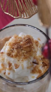 Krema dökülmüş uzun bir bardakta buzlu kahve. Koyu beton bir masada buz küpleri ve fasulyeler. Hindistan cevizi ve kremalı buzlu latte.