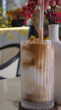 Sütlü krema buzlu kahveye dökülür. Buzlu ve sütlü soğuk kahve. Kahveyi süte dök. Buzlu latte karışımı.