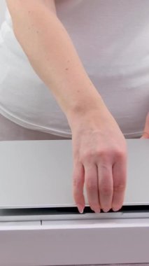 Bir kadın yeni bir MacBook ile bir kutu açar, koruyucu filmi çıkarır ve Polonya yapımı bir MacBook 06.17.2024 Varşova 'yı açar. 