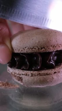 Kadın eli, beyaz ahşap arka planda mavi tabakta çatalla kremalı pasta kırıyor. Yan görünüm, 