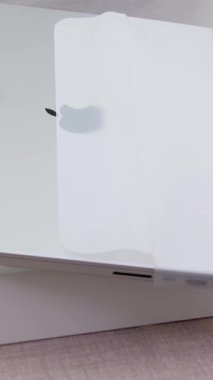 Bir kadın yeni bir MacBook ile bir kutu açar, koruyucu filmi çıkarır ve Polonya yapımı bir MacBook 06.17.2024 Varşova 'yı açar. 
