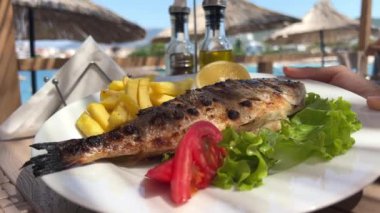 Patateslerin arasında, sarımsaklı limon ve biberiyeli bir tepside pişirilmiş deniz kremalı balık. Lezzetli gilthead deniz ürünleri. Yemekten çıkan sıcak buharla taze pişmiş. Dorado kızarmış.