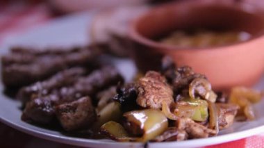 Lula kebap ızgarası, barbekü, patates kaması, tatlı biber, domates, pide, kesme tahtasında kırmızı beyaz sos, üst manzara. Kapatın. Fasulye ve güveç.