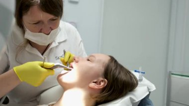Dentists hands giving anesthetic injection to female patient during dental procedure in clinic. Doctor making anesthetic injection to woman in dentistry office. Dental treatment concept.