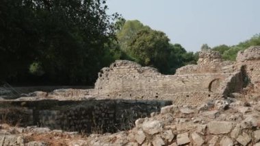 Arnavutluk 'un Butrint kentindeki eski şatoyu restore etti. Ormandaki harabelerin havadan görünüşü. Butrint Arkeoloji Parkı. İnsansız hava aracı videosu. Butrint Arnavutluk