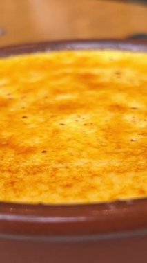 Masada güneş ışığıyla servis edilen ramekin ile servis edilen karamel kabuklu tatlı creme brulee.