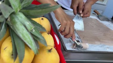 Dondurulmuş tavada rulo. Soğuk tabakta el yapımı dondurmalı tatlı. Çelik soğutmalı kızarmış dondurma makinesi. Kızarmış dondurma.