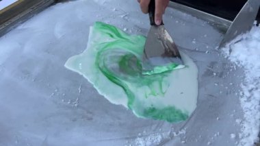 Dondurmalar soğuk tabak üzerinde Tayland usulü sokak yemekleri hazırlıyor. El yapımı kızarmış donmuş yoğurt, tavada meyveli tatlı. Kızarmış dondurma.