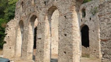 Arnavutluk 'un Butrint kentindeki eski şatoyu restore etti. Ormandaki harabelerin havadan görünüşü. Butrint Arkeoloji Parkı. İnsansız hava aracı videosu. Butrint Arnavutluk