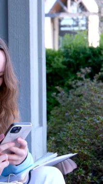 Sarışın kadın dışarıda akıllı telefondan yazı yazıyor. Yüksek kalite 4k görüntü