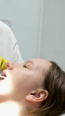 Dentists hands giving anesthetic injection to female patient during dental procedure in clinic. Doctor making anesthetic injection to woman in dentistry office. Dental treatment concept.