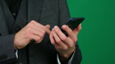 Mans Hand Holding Cep Telefonu. Yeşil Krom Anahtar Arkaplanı. Kaynaktan bir metin iletisi kaydır