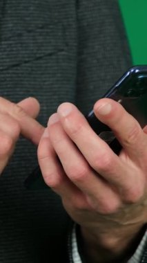 Mans Hand Holding Cep Telefonu. Yeşil Krom Anahtar Arkaplanı. Kaynaktan bir metin iletisi kaydır