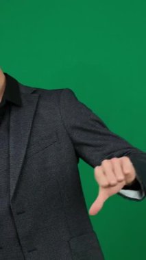 Tatminsizlik, yeşil arka plandaki yakışıklı adamın duygularını bastırıyor. Koyu renk saçlı, genç adam, reklamcılık yapıyor. Onaylamayan İşadamı Reddediyor