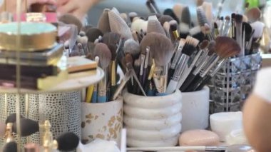 Büyük, bereketli fırça kazançları toz, bronzlaştırıcı ve makyaj malzemelerinin üzerine fosforlu kalem. Yüz paleti üzerinde çalışan bir sanatçı. Çalışma sürecinin ayrıntıları, güzellik endüstrisindeki aletler. Dekoratif kozmetik.