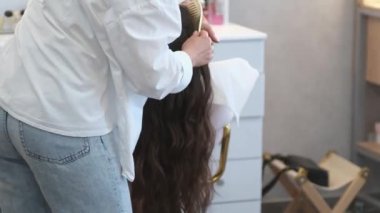 Bir kuaförde güzel bir saç stili yaratmak için siyah bir kadının saçını taramak ya da ayırmak için tarak kullanmak. Uzun kuaför salonunu tara