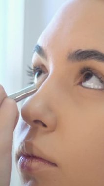 Makyöz bir kadına göz farı sürüyor. Makyajlı gözler.